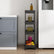 Slim black 4-tier trolley cart with olive oil, olives, pickles and vegetables between a cabinet and fridge