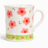 White ceramic mug with pink flowers, red berry sprigs and a lime-green tulip band