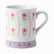 White ceramic mug with pink flowers, wavy pink stripes and a lilac floral band