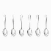 Six mirror-polished stainless steel coffee spoons lined up in a row