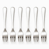 Six mirror-polished stainless steel dessert forks with 3 tines lined up in a row