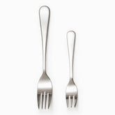 Mirror-polished stainless steel dinner fork and smaller dessert fork side by side