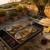 Grill basket with two whole sea bream and lemon slices over a charcoal mangal, with pita and tahini