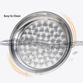 Water splashing over a stainless steel round tray to show it is easy to clean