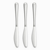 Three mirror-polished stainless steel table knives with serrated edges lined up in a row