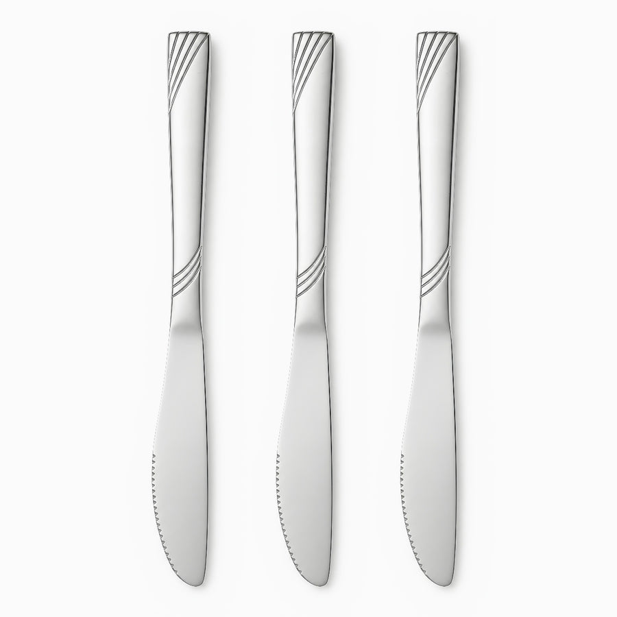 Three stainless steel table knives with engraved wave handles and serrated edges lined up in a row