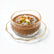 Hammered glass dessert bowl with thin gold rim on wavy gold-edged saucer filled with meghli