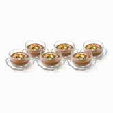 Set of 6 clear hammered glass dessert bowls with wavy saucers filled with meghli and nuts