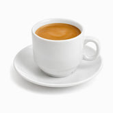 Single white porcelain coffee cup on its saucer filled with espresso and golden crema