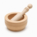 Wooden mortar and pestle set with the pestle resting in the bowl, carved grooves and ball-top handle