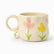 Cream ceramic mug with painted pink and yellow tulips and a looped ring handle